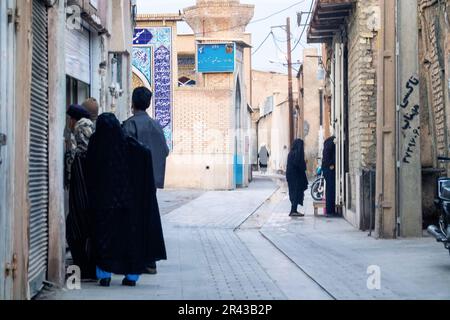 Shiraz, Iran - 31 dicembre 2022: Vecchie strade strette della città e dei loro abitanti - donne anziane in hijabs, la vita quotidiana Foto Stock