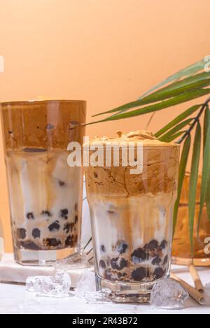 Caffè Boba dalgona. Drink mattutino asiatico alla moda con caffè istantaneo e palline di perle di tapioca, bicchiere da cocktail thai estivo in sole Foto Stock