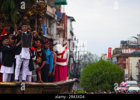 Un membro nepalese di Guthi Sansthan che espone al pubblico la foto del “Dio della pioggia” Rato Machhindranath, orchiata da un gioiello nero, dal carro di t Foto Stock