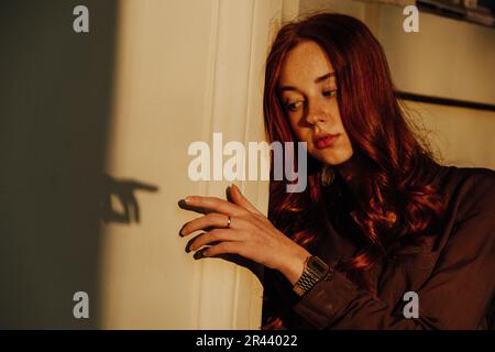Ginger Girl con Freckles al tramonto vicino a Old Architecture Foto Stock