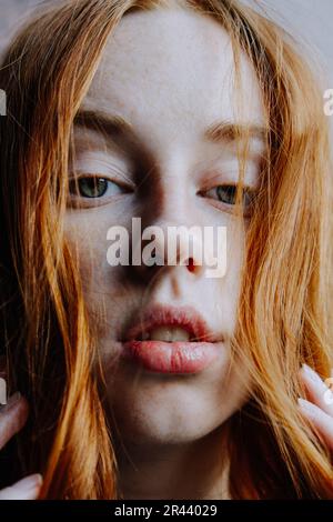 Ginger Girl con Freckles al tramonto vicino a Old Architecture Foto Stock