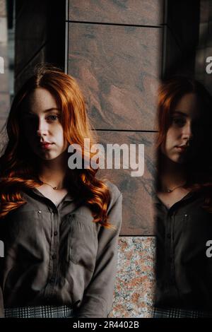 Ginger Girl con Freckles al tramonto vicino a Old Architecture Foto Stock