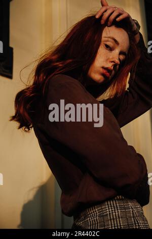Ginger Girl con Freckles al tramonto vicino a Old Architecture Foto Stock