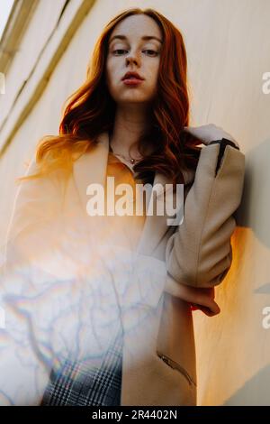 Ginger Girl con Freckles al tramonto vicino a Old Architecture Foto Stock