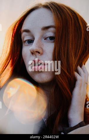 Ginger Girl con Freckles al tramonto vicino a Old Architecture Foto Stock