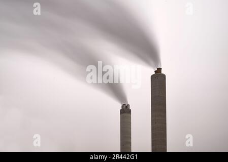 Esposizione lunga di fumo che esce da un camino di fabbrica Foto Stock