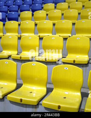 Posti a sedere vuoti gialli e blu allo stadio Foto Stock