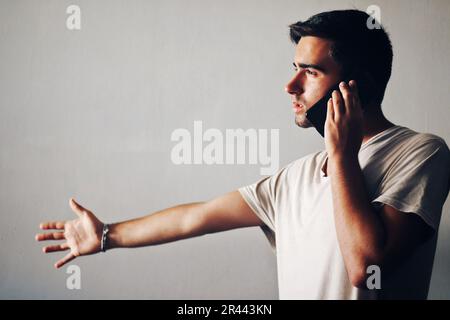 Uomo vestito di bianco che parla al telefono. Foto Stock