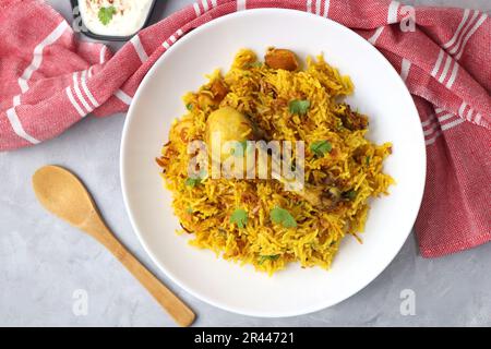 Pollo Biryani/murg Pulao. Guarnito con cipolla fritta e coriandolo tritato. Biryani servito con raita è un famoso piatto speziato non vegetariano dell'India. Foto Stock