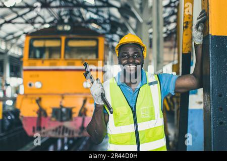 felice africano nero lavoratore ingegnere maschio che lavora pesante industria treno locomotiva servizio personale sorridente ritratto. Foto Stock