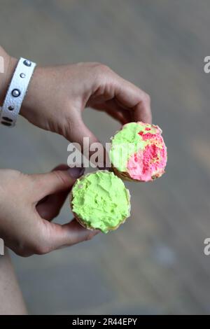 Una donna tiene un cono gelato in entrambe le mani. Il gelato è morso. Primo piano. Foto Stock
