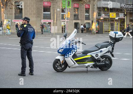 Un agente della polizia urbana con la sua BMW C Evoluiton scooter che regola il traffico a un bivio Foto Stock