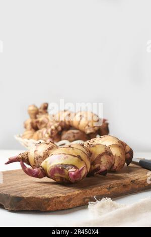 mucchio di razomi o tuberi della pianta di canna o del colpo indiano, indica di canna, yam valutato medicinale nativo alle regioni tropicali e subtropicali messe su legno Foto Stock