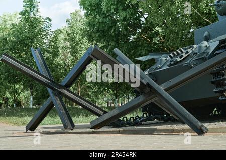 MOGILEV, BIELORUSSIA MAGGIO 21 2023 ricci anticarro e closeup serbatoio e sfondo pacifico. Monumento alle vecchie armi primo piano. Simbolo della fine della guerra. Vecchio Foto Stock