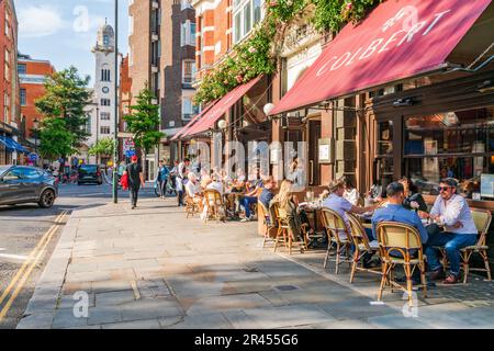 LONDRA, Regno Unito - 24 MAGGIO 2023: Le persone godono di una soleggiata giornata primaverile a Chelsea, un'area ricca conosciuta per le eleganti boutique e i ristoranti di alto livello Foto Stock