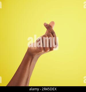 Mano, gesto per denaro e linguaggio dei segni di uomo closeup su sfondo studio per contanti, finanza o valuta. Sfregamento di persone, pollice e indice Foto Stock