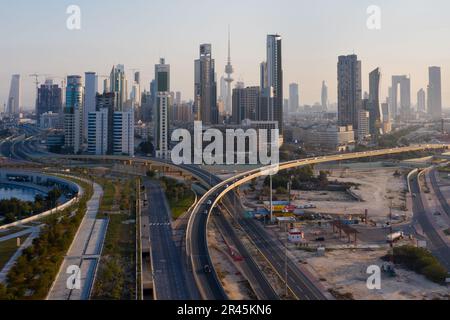 Vista aerea della città di Kuwait all'alba, che mostra il moderno skyline della città e le autostrade trafficate Foto Stock