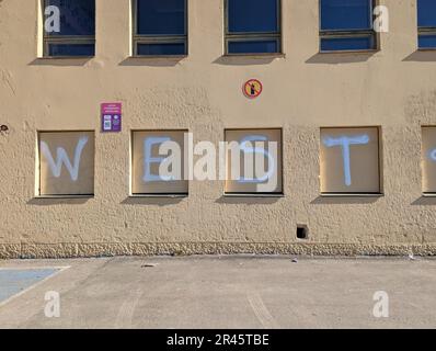 Primo piano di un murale dipinto sul lato di un edificio, l'iscrizione recita 'West' Foto Stock