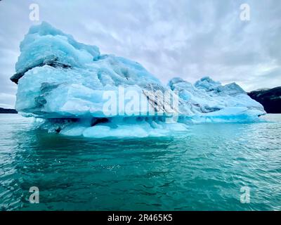 L'iceberg con ghiaccio blu del ghiacciaio in una giornata nuvolosa. Foto Stock