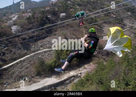 230331-N-BE774-1357 BUSAN, Repubblica di Corea (31 marzo 2023), Stati Uniti Navy Sailor assegnato alla portaerei USS Nimitz (CVN 68) zip-line durante un tour morale, benessere e ricreazione. Nimitz è presente negli Stati Uniti nel 7th Fleet e svolge operazioni di routine. 7th Fleet è la flotta statunitense La flotta numerata più grande della Marina e interagisce e opera regolarmente con alleati e partner per preservare una regione indomorosa e libera. Foto Stock