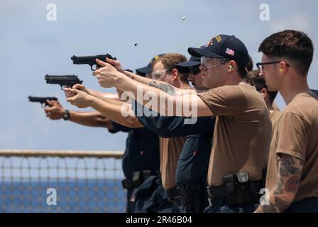 MARE DELLA CINA DEL SUD (27 marzo 2023) – i marinai assegnati al cacciatorpediniere missilistico guidato della classe Arleigh Burke USS Milius (DDG 69) sparano pistole da 9 mm durante un esercizio di fuoco vivo mentre operano nel Mar della Cina del Sud, marzo 27. Milius è assegnato al Comandante, Task Force 71/Destroyer Squadron (DESRON) 15, il più grande DESRON schierato in avanti della Marina e la principale forza di superficie della flotta degli Stati Uniti 7th. Foto Stock