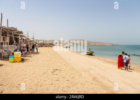 Una famiglia sul litorale di una spiaggia sull'isola di Hengam, una destinazione popolare fra i turisti nazionali in Iran Foto Stock