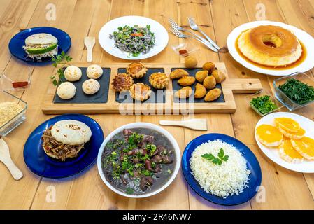 Set di deliziosi piatti brasiliani con riso, feijoada, dessert e arepas Foto Stock