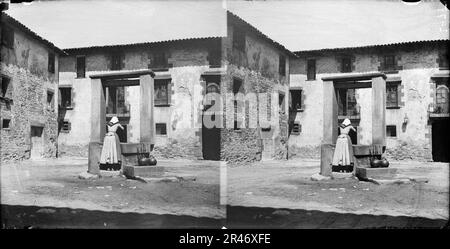 Una dona Traient aigua d'un pou a pla placa de Sant Julià de Vilatorta Foto Stock