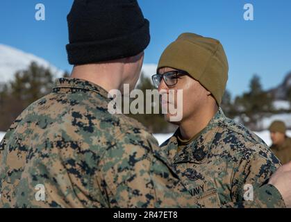 STATI UNITI Navy Petty Officer 2D Class Mason Monfrey, un corpsman con 2D Combat Engineer Battalion, spins U.S. Navy Petty Officer Classe 3rd, Kevin AyalaCalderon, un corpsman con 2D Combat Engineer Battalion, 2D Divisione Marina a Setermoen, Norvegia, Math 28, 2023. Il pin FMF indica gli Stati Uniti Ufficiali navali e marinai addestrati e qualificati per svolgere compiti a sostegno degli Stati Uniti Corpo marino. Foto Stock