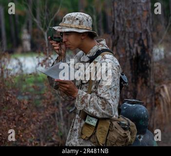 NEGLI STATI UNITI Marine Corps Recruit da Hotel Company, 2nd reclutamento addestramento battaglione, guarda attraverso la sua bussola durante il corso di navigazione terrestre su Marine Corps Recruit Depot Parris Island, South Carolina, 28 marzo 2023. Durante il corso, le reclute hanno dovuto navigare in vari punti di una mappa utilizzando una bussola. Foto Stock