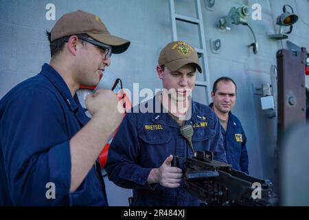 SINGAPORE (9 marzo 2023) Gunner’s Mate 2nd Classe Joshua Rodriguez, a sinistra, da Los Angeles, istruisce il Lt. j.g. Redd Whetsel, da North Bend, Washington, come far funzionare una mitragliatrice M2A1 durante l'addestramento di familiarizzazione con le armi a bordo della nave da combattimento litoranea USS Oakland (LCS 24) di classe Independence alla base navale di Changi, Singapore, 9 marzo 2023. Oakland, parte di Destroyer Squadron 7, è su un dispiegamento rotazionale, che opera nell'area delle operazioni della flotta degli Stati Uniti 7th per migliorare l'interoperabilità con gli alleati e i partner e servire come una forza di risposta pronta a sostegno di un libero e aperto Indo-Pacific re Foto Stock