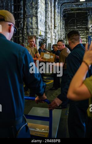 SINGAPORE (14 marzo 2023) i marinai spostano le forniture durante un negozio a bordo della nave da combattimento litoranea di classe Independence USS Oakland (LCS 24) presso la base navale di Changi, Singapore, 14 marzo 2023. Oakland, parte di Destroyer Squadron 7, è in fase di implementazione a rotazione, che opera nell'area operativa della flotta degli Stati Uniti 7th per migliorare l'interoperabilità con gli alleati e i partner e funge da forza di risposta pronta a sostegno di una regione indomPacifico libera e aperta. Foto Stock