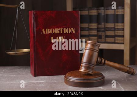 Abortire Law book, Gavel e scale di giustizia su tavola di marmo marrone Foto Stock