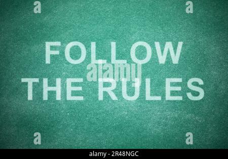 Frase seguire le regole scritte sulla lavagna verde Foto Stock
