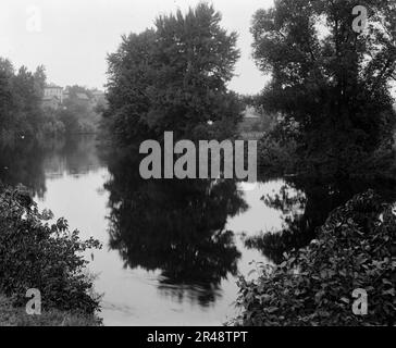 Fiume con edifici sullo sfondo, probabilmente il fiume Huron, Ypsilanti, Michigan, tra il 1900 e il 1910. Foto Stock