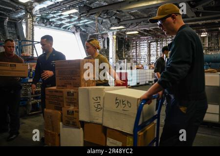 SINGAPORE (14 marzo 2023) i marinai spostano le forniture durante un negozio a bordo della nave da combattimento litoranea di classe Independence USS Oakland (LCS 24) presso la base navale di Changi, Singapore, 14 marzo 2023. Oakland, parte di Destroyer Squadron 7, è in fase di implementazione a rotazione, che opera nell'area operativa della flotta degli Stati Uniti 7th per migliorare l'interoperabilità con gli alleati e i partner e funge da forza di risposta pronta a sostegno di una regione indomPacifico libera e aperta. Foto Stock