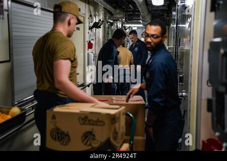 SINGAPORE (14 marzo 2023) i marinai spostano le forniture durante un negozio a bordo della nave da combattimento litoranea di classe Independence USS Oakland (LCS 24) presso la base navale di Changi, Singapore, 14 marzo 2023. Oakland, parte di Destroyer Squadron 7, è in fase di implementazione a rotazione, che opera nell'area operativa della flotta degli Stati Uniti 7th per migliorare l'interoperabilità con gli alleati e i partner e funge da forza di risposta pronta a sostegno di una regione indomPacifico libera e aperta. Foto Stock