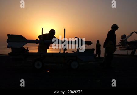 US Navy Aviation Ordnancemen spostare AIM-9M Sidewinder air-to-air missile per aeromobili sul ponte di volo della nave Foto Stock