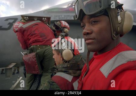 Gli USA Navy Aviation Ordnancemen sul ponte di volo a bordo della portaerei USS Harry S. Truman (CVN 75) caricano munizioni nel cannone naso da 20 mm di un F-A-18 Hornet Foto Stock