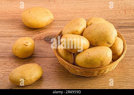 Una generosità di patate di un contadino esposta su un rustico tavolo di legno Foto Stock