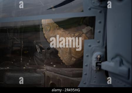 NEGLI STATI UNITI Air Force HH-60G il pilota di nave Hawk assegnato al 33rd Rescue Squadron appoggia un piede sul pedale anti-coppia del rotore posteriore mentre conduce i controlli pre-volo alla base aerea di Kadena, Giappone, 29 marzo 2023. Il 33rd RQS si adopera per la mobilitazione, lo spiegamento e l'impiego di elicotteri e per il salvataggio di militari statunitensi e alleati e di personale civile. Foto Stock