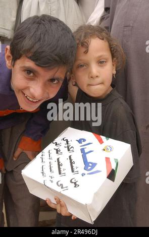 US Navy i bambini iracheni mostrano razioni di cibo umanitario distribuite da cittadini del Kuwait e degli Stati Uniti Soldati dell'esercito durante uno sforzo per distribuire cibo e acqua ai cittadini iracheni bisognosi Foto Stock