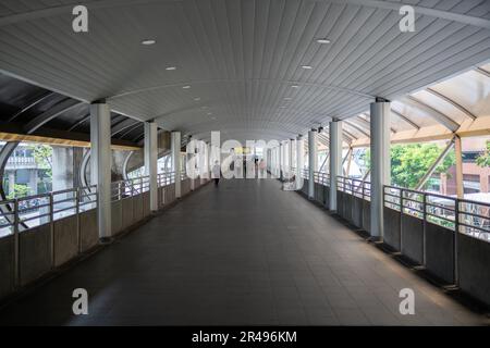 Persone che camminano sul ponte Skywalk collegato tra la stazione BTS Chong Nonsi e il ponte Chong Nonsi a Bangkok, Thailandia. Foto Stock