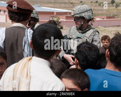 (Provincia di kapisa, Afghanistan) Stati Uniti Air Force 1st Lt. Amanda Huffman parla con gli afghani locali al di fuori della scuola Malakar, di recente costruzione, nel villaggio di Durnama. Il Lt. Huffman è membro del Provincial Reconstruction Team Kapisa e svolge regolarmente missioni in tutto il Kapisa per interagire e interagire con i leader locali. La missione del PRT è quella di stabilizzare la regione consentendo ai governi locali di prendersi cura, istruire, impiegare e proteggere le loro persone attraverso la costruzione di infrastrutture di base e di tutoraggio. Foto Stock