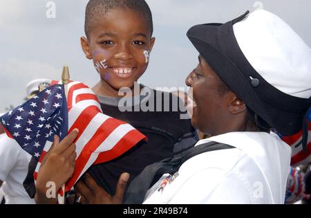 US Navy Un Sailor dalla nave anfibia di comando e controllo USS Mount Whitney (LCC-JCC 20) gioisce dopo essere stato riunito con la sua famiglia Foto Stock