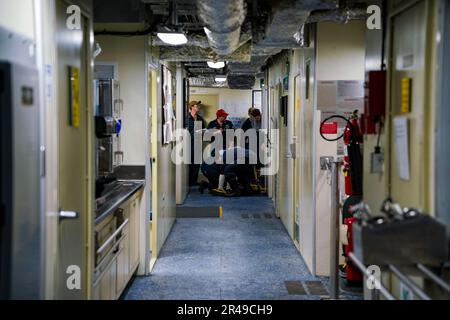 SINGAPORE (15 marzo 2023) i marinai indossano dispositivi di protezione personale durante un'esercitazione di controllo dei danni a bordo della nave da combattimento litoranea USS Oakland (LCS 24) di classe Independence presso la base navale di Changi, Singapore, 15 marzo 2023. Oakland, parte di Destroyer Squadron 7, è in fase di implementazione a rotazione, che opera nell'area operativa della flotta degli Stati Uniti 7th per migliorare l'interoperabilità con gli alleati e i partner e funge da forza di risposta pronta a sostegno di una regione indomPacifico libera e aperta. Foto Stock