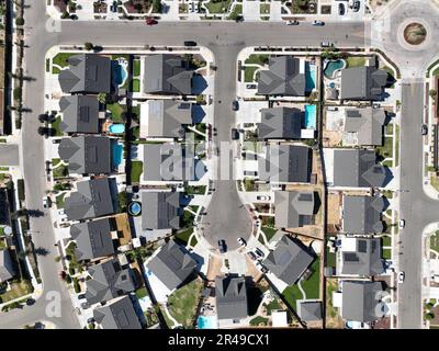 Vista aerea di una zona residenziale nei sobborghi con una strada asfaltata che si snoda attraverso il quartiere Foto Stock