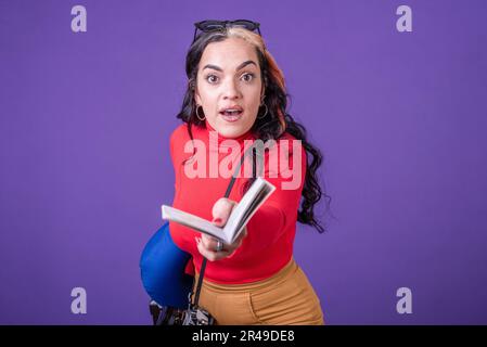 Donna in possesso di passaporto e valigia mentre corre su sfondo viola. Vista frontale. Foto da studio. Foto Stock