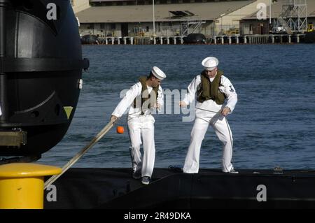 I gestori DELLA US Navy Line a bordo della USS Los Angeles (SSN 688) portano le linee di ormeggio per assicurare il sottomarino al suo ormeggio a Pearl Harbor Foto Stock