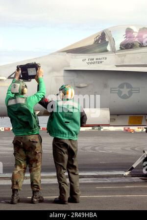 IL personale del ponte di volo della Marina DEGLI STATI UNITI mostra una tavola dei pesi degli aeromobili al pilota di un F-A-18C Hornet assegnato ai Stingers of Strike Fighter Squadron One One One One One Three (VFA-113) sul ponte di volo a bordo della nave USS John Foto Stock